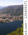 Aerial view of Como city and Lake Como, surrounded by lush hills and mountains, with boats on the water and scenic urban landscape in northern Italy. 126409371