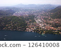 Aerial view of Como city and Lake Como, surrounded by lush hills and mountains, with boats on the water and scenic urban landscape in northern Italy. 126410008
