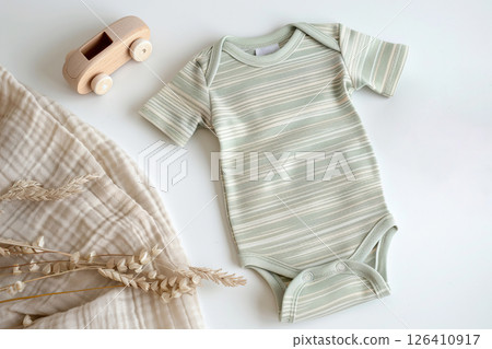 Baby boy onesie on a light background. Fashion newborn clothes. Flat lay, top view. Baby kids soft clothing set, wooden toys. Infant trendy bodysuit made of organic eco friendly cotton. Gender neutral Baby boy onesie on a light background. Fashion newborn clothes. Flat lay, top view. Baby kids soft clothing set, wooden toys. Infant trendy bodysuit made of organic eco friendly cotton. Gender neutral 126410917