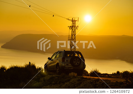 High voltage towers on coast at sunset High voltage towers on coast at sunset 126410972