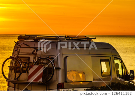 Camper with bicycles on rack camping on beach at sunrise Camper with bicycles on rack camping on beach at sunrise 126411192