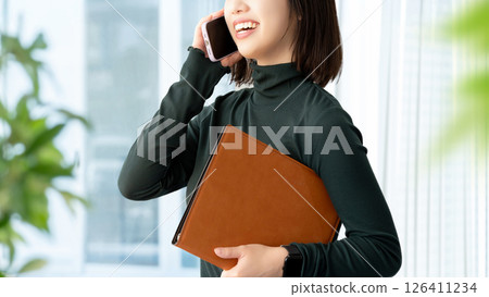 Smiling woman/businesswoman talking on smartphone Smiling woman/businesswoman talking on smartphone 126411234