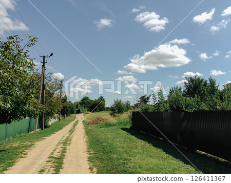 Dirt road with a fence on the side Dirt road with a fence on the side 126411367
