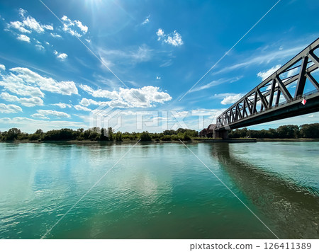 Bridge spans a river with a clear blue sky above 126411389