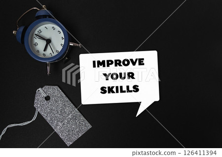 Blue alarm clock sits on a black background with the words improve your skill 126411394