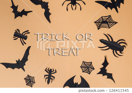Trick or treat is written in white letters on a background of black bats Trick or treat is written in white letters on a background of black bats 126411545