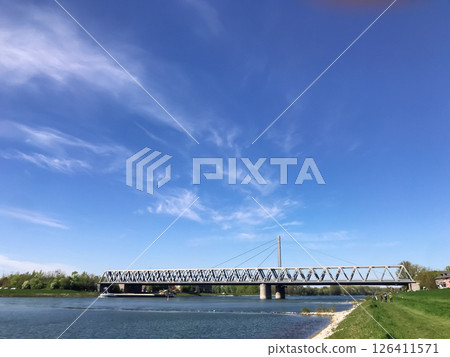 A bridge spans a river with a clear blue sky above 126411571