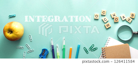 A green background with a bunch of school supplies and an apple 126411584