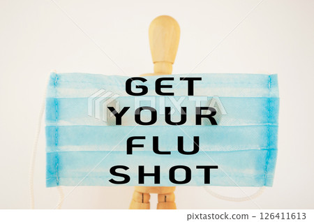 Man wearing a blue mask with the words get your flu shot written on it 126411613