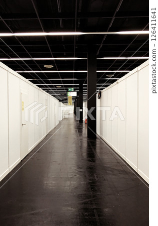 Long hallway with a black floor and white walls, refugee camp in Cologne Long hallway with a black floor and white walls, refugee camp in Cologne 126411641