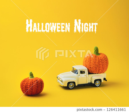 White truck is carrying two orange pumpkins 126411661