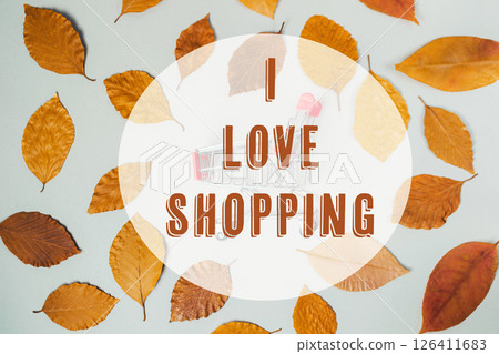 A leafy background with the words I love shopping written in the center 126411683