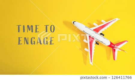 A small airplane is on a yellow background with the words Time to Engage A small airplane is on a yellow background with the words Time to Engage 126411766