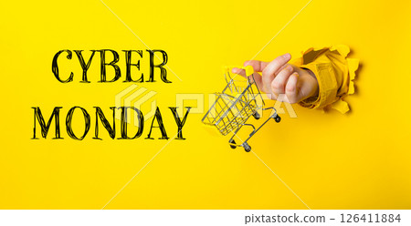 Hand holding a shopping cart with the words Cyber Monday written underneath 126411884