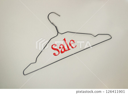 Metal clothes hanger with the word Sale written on it 126411901