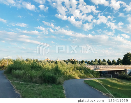 A bridge spans a river with a green field on either side A bridge spans a river with a green field on either side 126411959