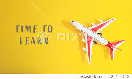 Toy airplane is on a yellow background with the words Time to Learn Toy airplane is on a yellow background with the words Time to Learn 126411960