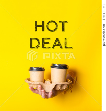 A person holding two cups with the words hot deal written on the background A person holding two cups with the words hot deal written on the background 126411962