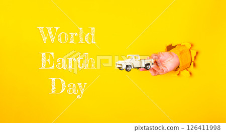 Hand holding a toy truck in front of a yellow background Hand holding a toy truck in front of a yellow background 126411998