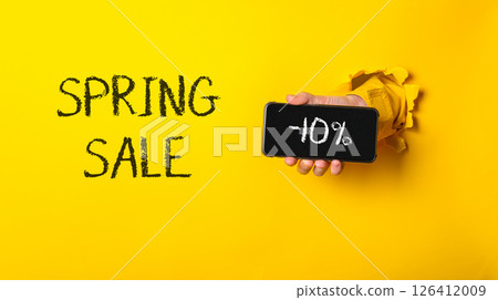 Person holding a cell phone with the words Spring Sale written on it 126412009