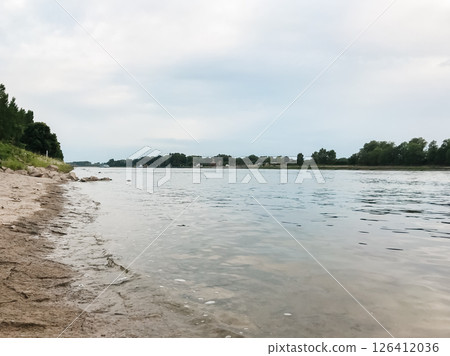 A calm lake with a cloudy sky in the background 126412036