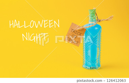 Bottle of blue liquid with a tag that says Halloween Night Trick or Treat Bottle of blue liquid with a tag that says Halloween Night Trick or Treat 126412063