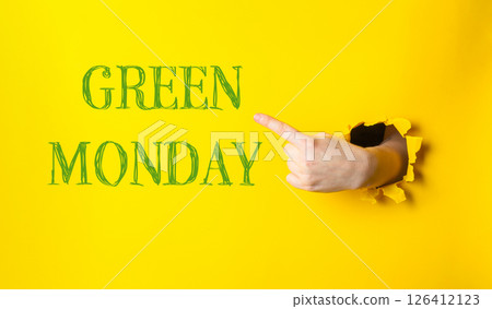 Hand pointing to the word green monday on a yellow background Hand pointing to the word green monday on a yellow background 126412123