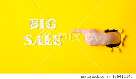 Hand pointing to the word big sale on a yellow background Hand pointing to the word big sale on a yellow background 126412143
