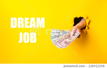 Hand holding a stack of money with the words dream job written below it 126412249