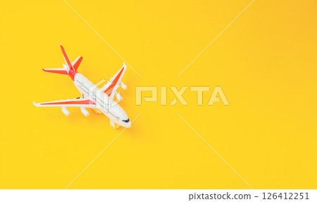 Toy airplane is sitting on a yellow background 126412251