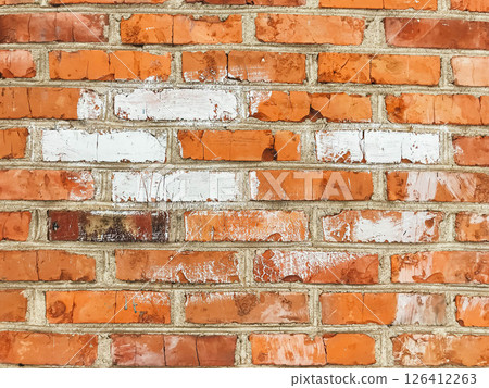 A brick wall with a white line painted on it 126412263
