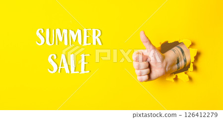 Hand is giving a thumbs up in front of a yellow background Summer Sale Hand is giving a thumbs up in front of a yellow background Summer Sale 126412279