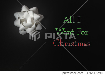 White bow with red and green trim is on a black background 126412290