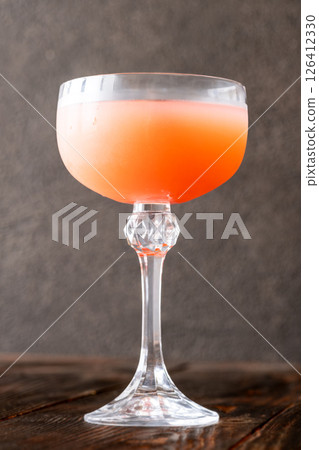 Guayaba Arabica cocktail blends guava, coffee, and rum in moody coupe glass Guayaba Arabica cocktail blends guava, coffee, and rum in moody coupe glass 126412330