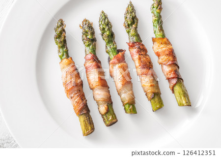 Crispy Fried Asparagus Wrapped In Bacon Served Simply On White Plate 126412351