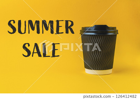 Black coffee cup with a white lid sits on a yellow background Black coffee cup with a white lid sits on a yellow background 126412482