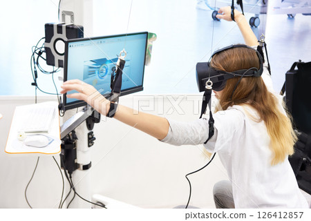Woman on stand with virtual reality device for rehabilitation Woman on stand with virtual reality device for rehabilitation 126412857