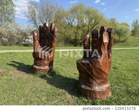 Two Wooden Armchairs Sculpted as Giant Hands in Park 126413278