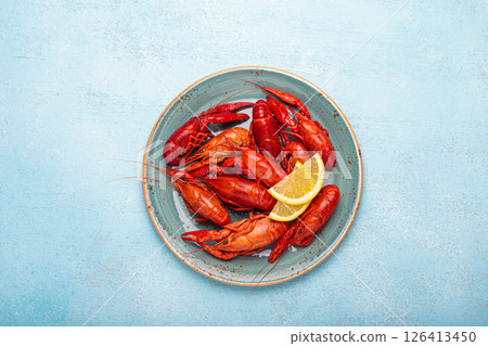 Delicious cooked crayfish with lemon slices on rustic blue plate top view Delicious cooked crayfish with lemon slices on rustic blue plate top view 126413450