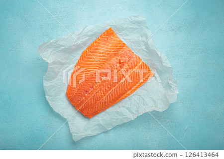 Fresh raw salmon fillet lying on white baking paper 126413464