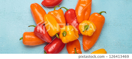 Sweet mini peppers lying on a blue tabletop 126413469