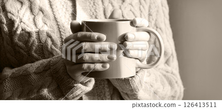Hands with a cup of hot tea 126413511