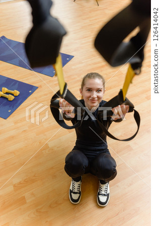 Young woman training with trx fitness straps in the gym. 126414042