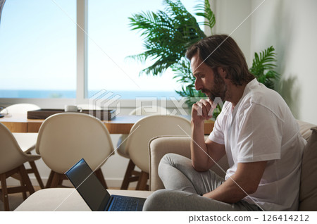 Man Focused on Remote Work in Contemporary Home Interior 126414212