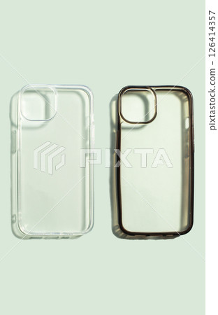 Two smartphone cases, one new and clean and other old and dirty on soft green background, highlighting their before and after usage and protective qualities for mobile devices. Two smartphone cases, one new and clean and other old and dirty on soft green background, highlighting their before and after usage and protective qualities for mobile devices. 126414357