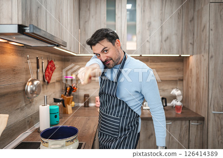 Man in the kitchen having fun while cooking 126414389