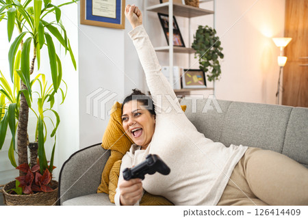 Woman having fun playing video games at home 126414409