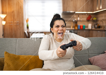 Competitive woman playing video game at home 126414410