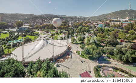 Aerial timelapse of Rike Park, a modern urban park in Tbilisi's Old Town with green trees and lawns. The Bridge of Peace in the background. Georgia Aerial timelapse of Rike Park, a modern urban park in Tbilisi's Old Town with green trees and lawns. The Bridge of Peace in the background. Georgia 126415006
