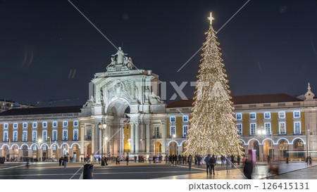 Commerce Square in Lisbon illuminated at Christmas hyperlapse, with a towering tree and crowds celebrating at night. Portugal 126415131